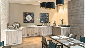 A modern kitchen with a central island, pendant lighting, and a dining area with tables and chairs. - Urban Studios by Velvet Luxury (Medellín)