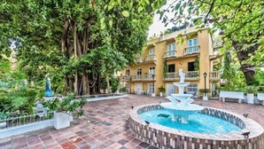A courtyard with a fountain, surrounded by a tiled floor and lush greenery. - Santo Domingo Condos by Velvet Luxury (Cartagena)