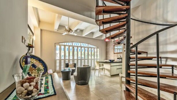 A modern interior with a spiral staircase, a dining area with a view, and a kitchen. - Santo Domingo Condos by Velvet Luxury (Cartagena)