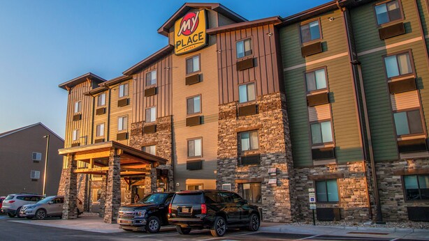 Un hotel de varios pisos con fachada de piedra y un letrero que dice 'My Place Hotel'.