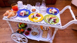A breakfast trolley with croissants, sandwiches, and a variety of fruits and beverages. - Le Nicchie luxury rooms (Lecce)