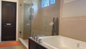 Luxe studio suite | Badkamer | Een bad/douchecombinatie, een diep bad, een hydromassagedouche