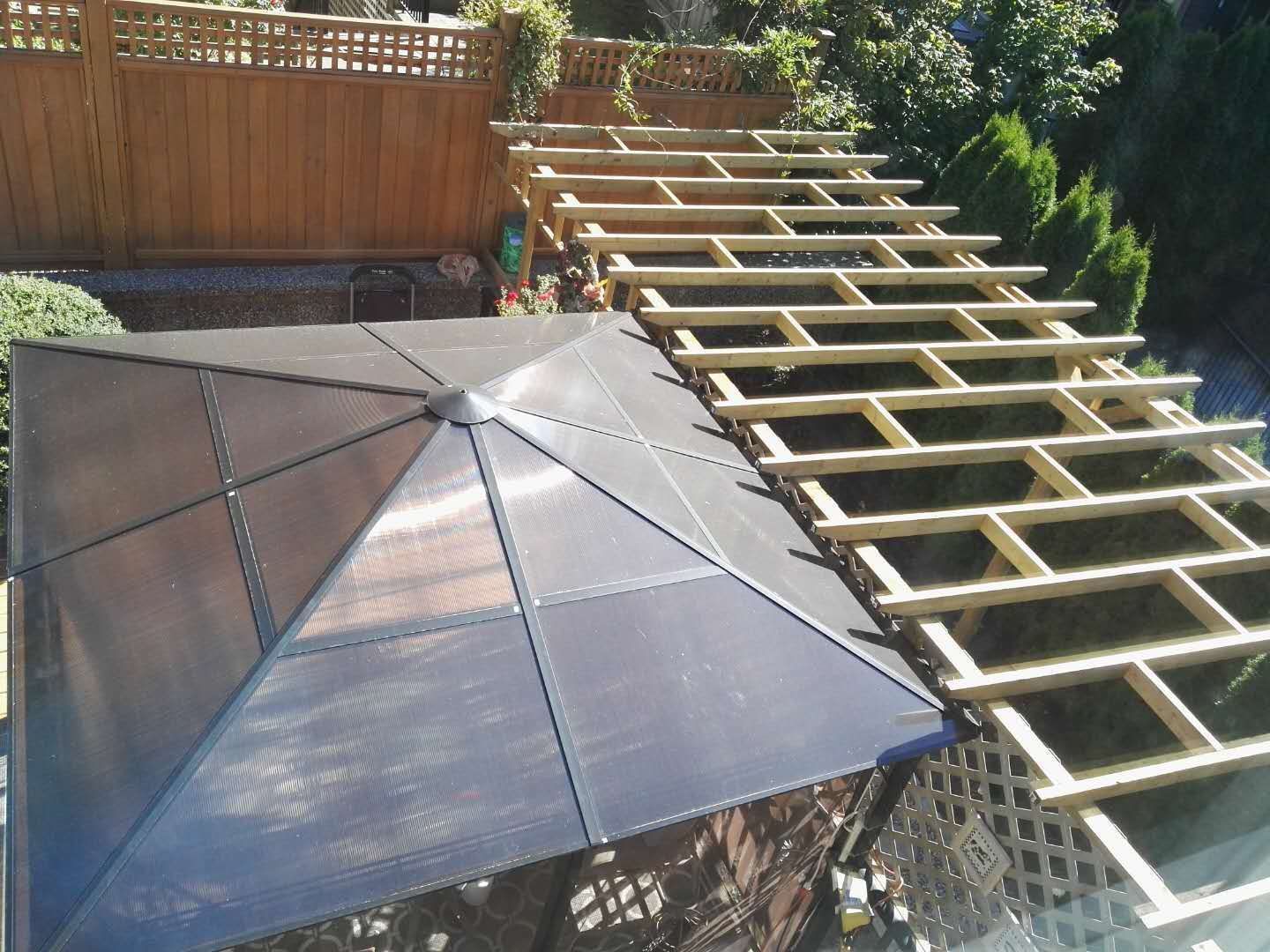 Una azotea con una gran estructura tipo sombrilla oscura y vigas de madera.
