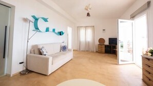 Ein geräumiges Wohnzimmer mit einer Couch, einem Couchtisch und einem Fernseher.