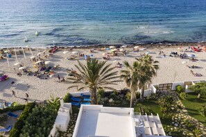 A beach with sun loungers, umbrellas, and palm trees. - RANDOM LISTING (TRAPANI)