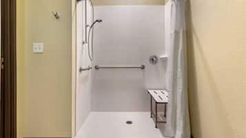 A small, enclosed shower area with a bench, a towel rack, and a shower curtain.