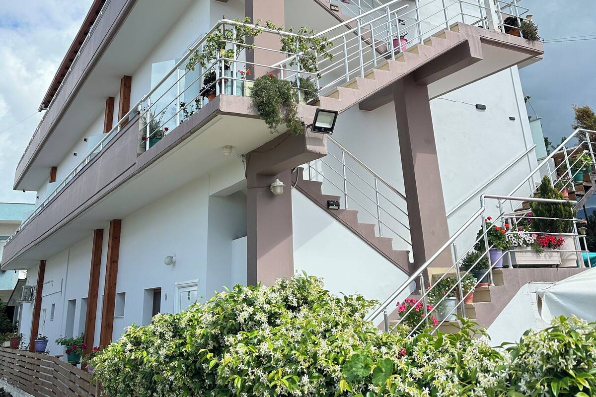 A multi-story building with balconies, staircases, and potted plants.