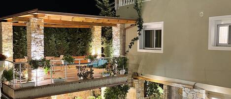 A multi-level outdoor patio with stone flooring, seating areas, and potted plants.