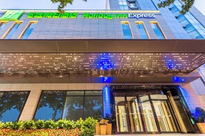 A Holiday Inn Express building with a modern facade, large windows, and a well-lit entrance. - Holiday Inn Express Xi'An Ancient Town West by IHG (Xi'an)