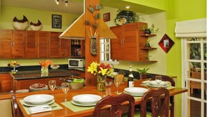 A dining area with a wooden table set for four, surrounded by wooden chairs. - Bamboo Manor (Playa del Carmen)