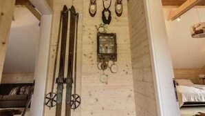 A wooden interior with a sloped ceiling, a wall-mounted clock, and antlers. - Steirer Apartment with Small Balcony - Steirer Apartment (Semmering-Kurort)