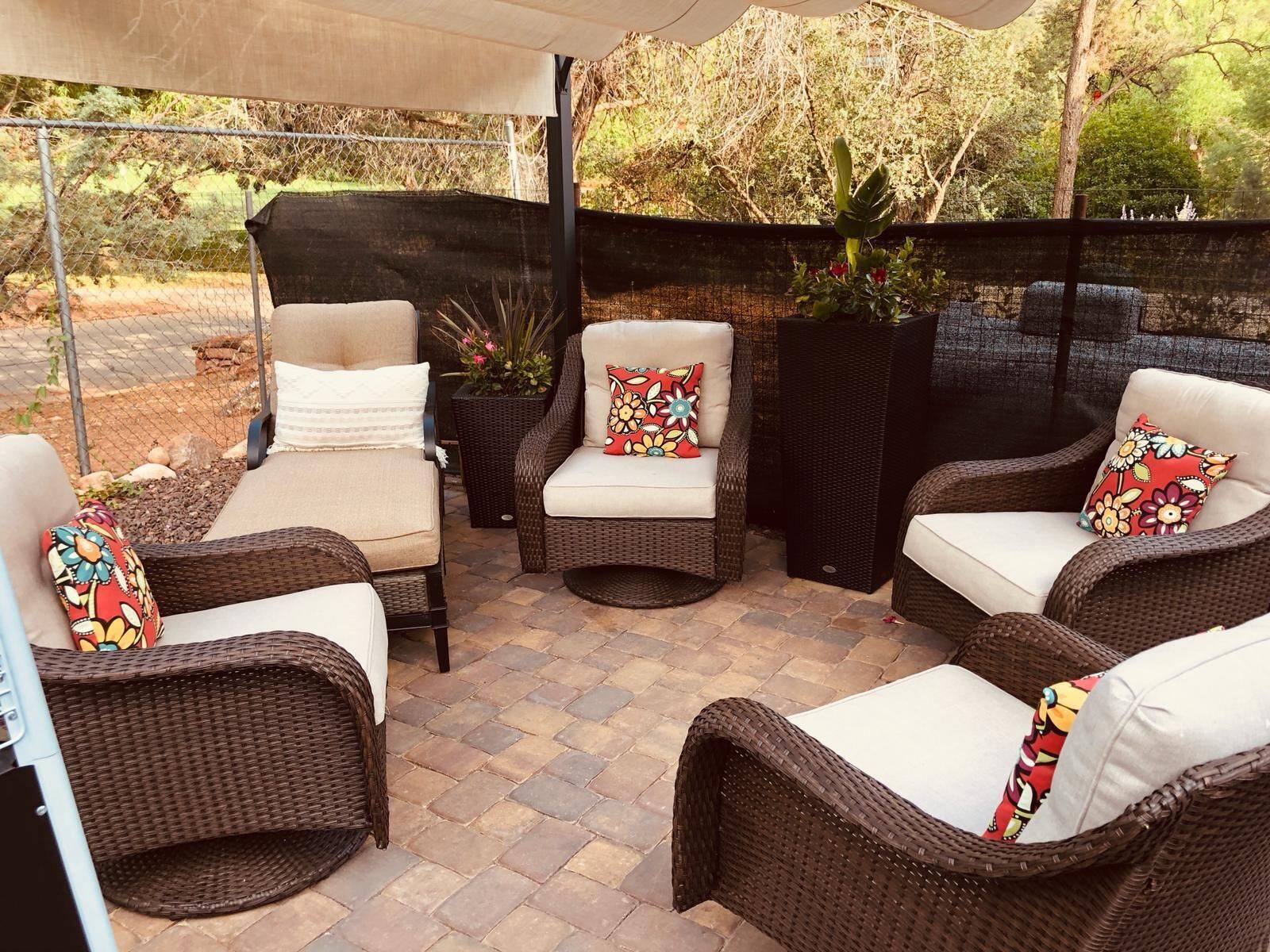 An outdoor patio area with wicker furniture and a covered section.