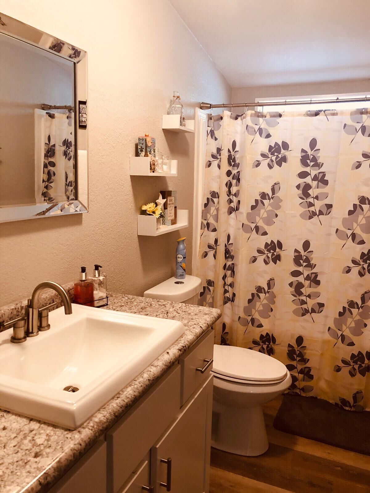 A bathroom with a sink, toilet, and shower curtain.