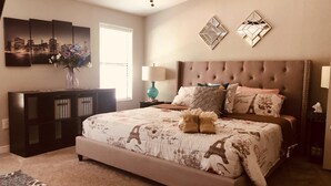 A bedroom with a large bed, a dresser, a nightstand, and a wall-mounted lamp. - Sedona Red Rock Garden of Paradise, Pets friendly and Hot Tub (Sedona)