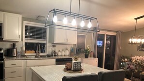 A modern kitchen with white cabinets, a herringbone tile backsplash, and a central island with chairs. - Sedona Red Rock Garden of Paradise, Pets friendly and Hot Tub (Sedona)