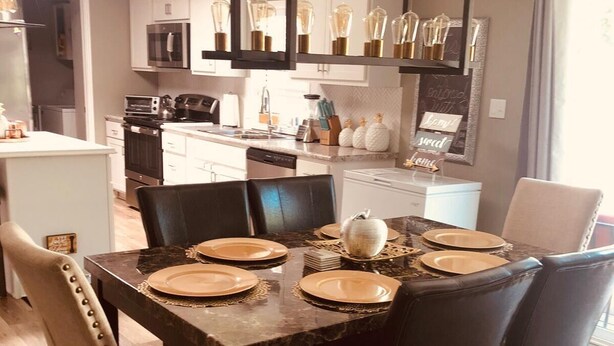 A modern dining area with a dark wooden table set for four, surrounded by leather chairs. - Sedona Red Rock Garden of Paradise, Pets friendly and Hot Tub (Sedona)
