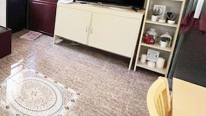 A living room with a sofa, TV, and decorative items. - Town House Next to the Beach - TALOMO TORIL DAVAO (Talomo)