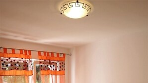 A bedroom with a bed, a window with curtains, a bedside table with a lamp, and a shelf with decorative items. - Apartment in Rovinj with Terrace, Air condition, WIFI, Dishwasher (4285-2) (Rovinj)