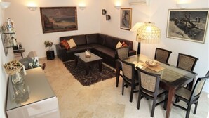 A living room with a sofa, coffee table, dining table with chairs, and artwork on the walls. - Apartment in Rovinj with Terrace, Air condition, WIFI, Dishwasher (4285-2) (Rovinj)