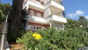 A multi-story residential building with balconies, surrounded by greenery and a large tree. - Apartment in Rovinj with Terrace, Air condition, WIFI, Dishwasher (4285-2) (Rovinj)