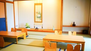 Una habitación japonesa tradicional con suelo de tatami, una mesa baja y una puerta corredera.