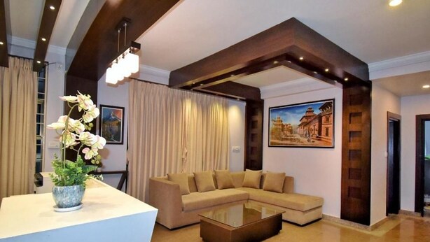 Una sala de estar moderna con un sofá modular, una mesa de centro de vidrio y una planta decorativa.