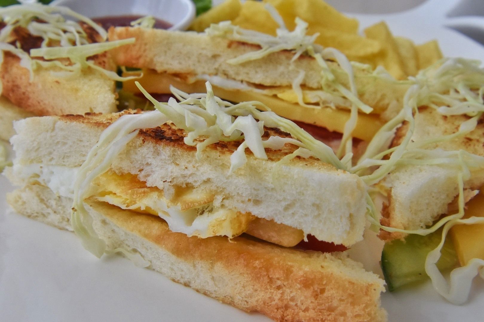 Un sándwich con lechuga y una guarnición de papas fritas.
