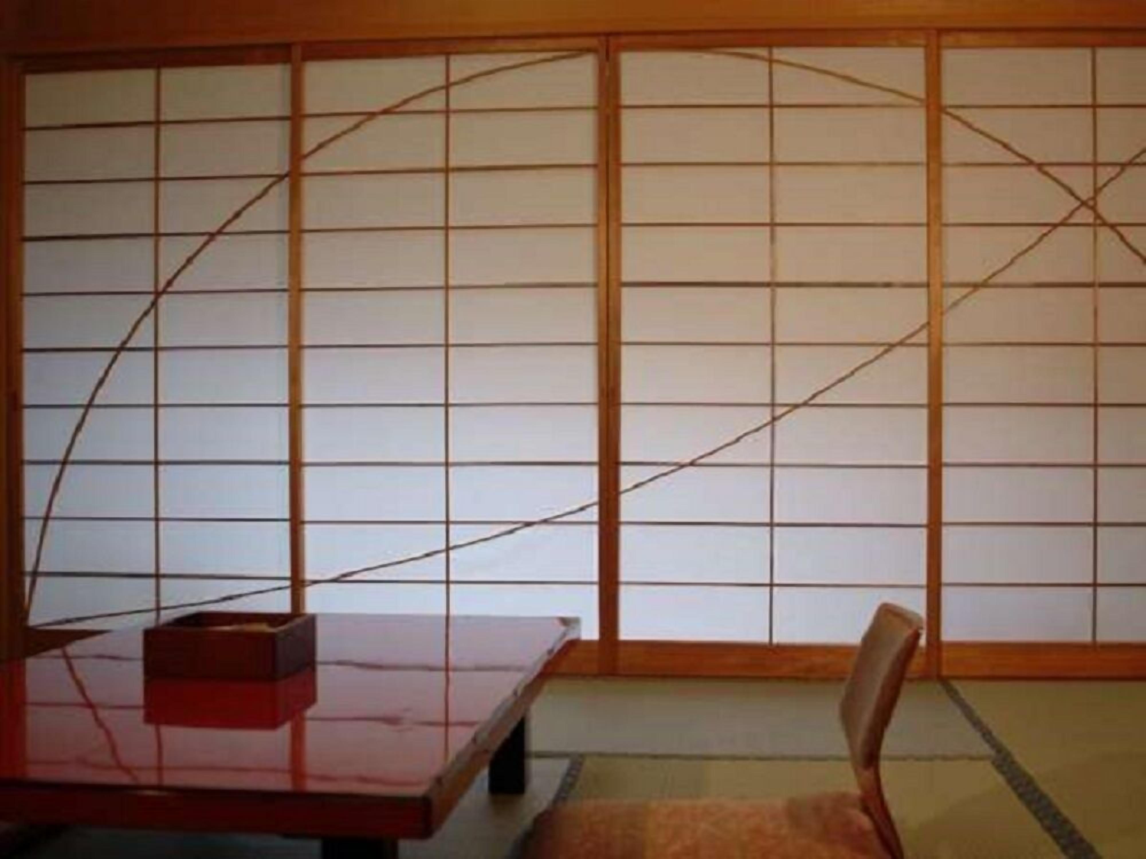 A traditional Japanese room with tatami flooring, a low wooden table, and a sliding shoji screen.
