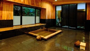 A modern interior with wooden paneling, a large window, and a stone floor. - Misasaonsen Kouraku (Misasa)