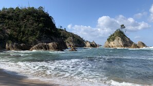 A beach with rocky outcrops and clear blue water. - Misasaonsen Kouraku (Misasa)