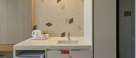 Une salle de bain moderne avec un lavabo, un miroir et des toilettes. On trouve un porte-serviettes au-dessus du lavabo et un meuble en dessous.