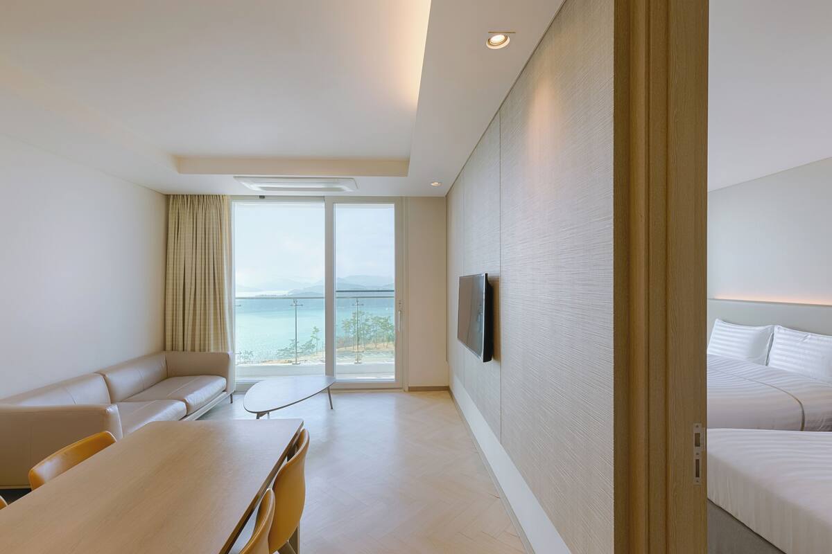 Una habitación de hotel moderna con sofá, mesa de comedor y cama.