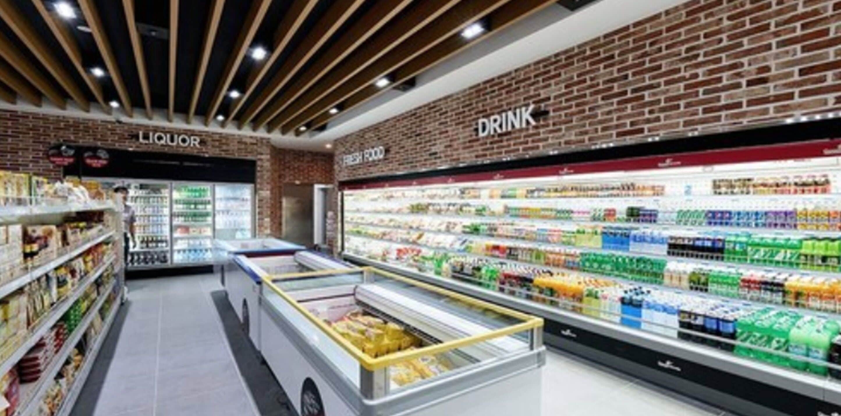 Una tienda de comestibles con secciones refrigeradas para alimentos frescos y una sección de licores.