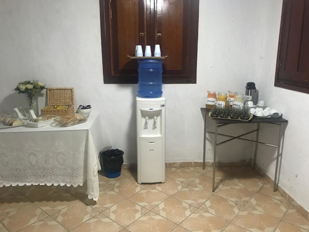 Uma pequena cozinha compacta com um bebedouro, uma mesa com alimentos e um espaço para café.