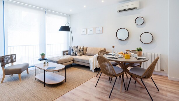 Una sala de estar moderna con sofá, mesa de centro y comedor.