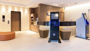 A modern reception area with a digital kiosk, wooden paneling, and a seating area. - Keikyu EX Inn Akihabara (Tokyo)