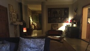 A cozy living room with a sofa, a fireplace, and a bookshelf. - Sommerhof in the beautiful Havelland (Märkisch Luch OTBuschow)