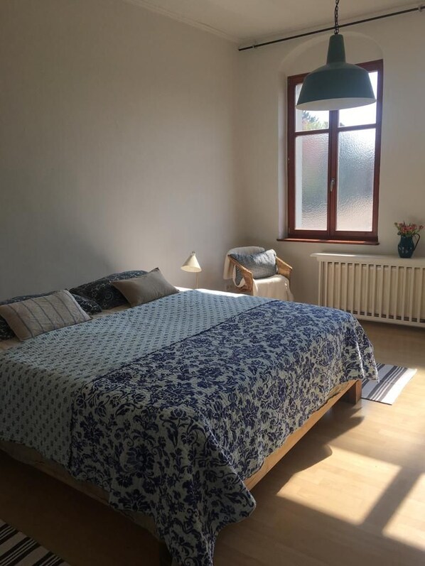 A bedroom with a bed, a chair, a window, and a radiator. - Sommerhof in the beautiful Havelland (Märkisch Luch OTBuschow)