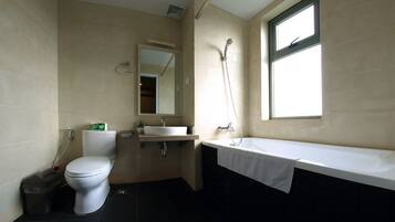 Une salle de bain avec des toilettes, un lavabo et une baignoire.