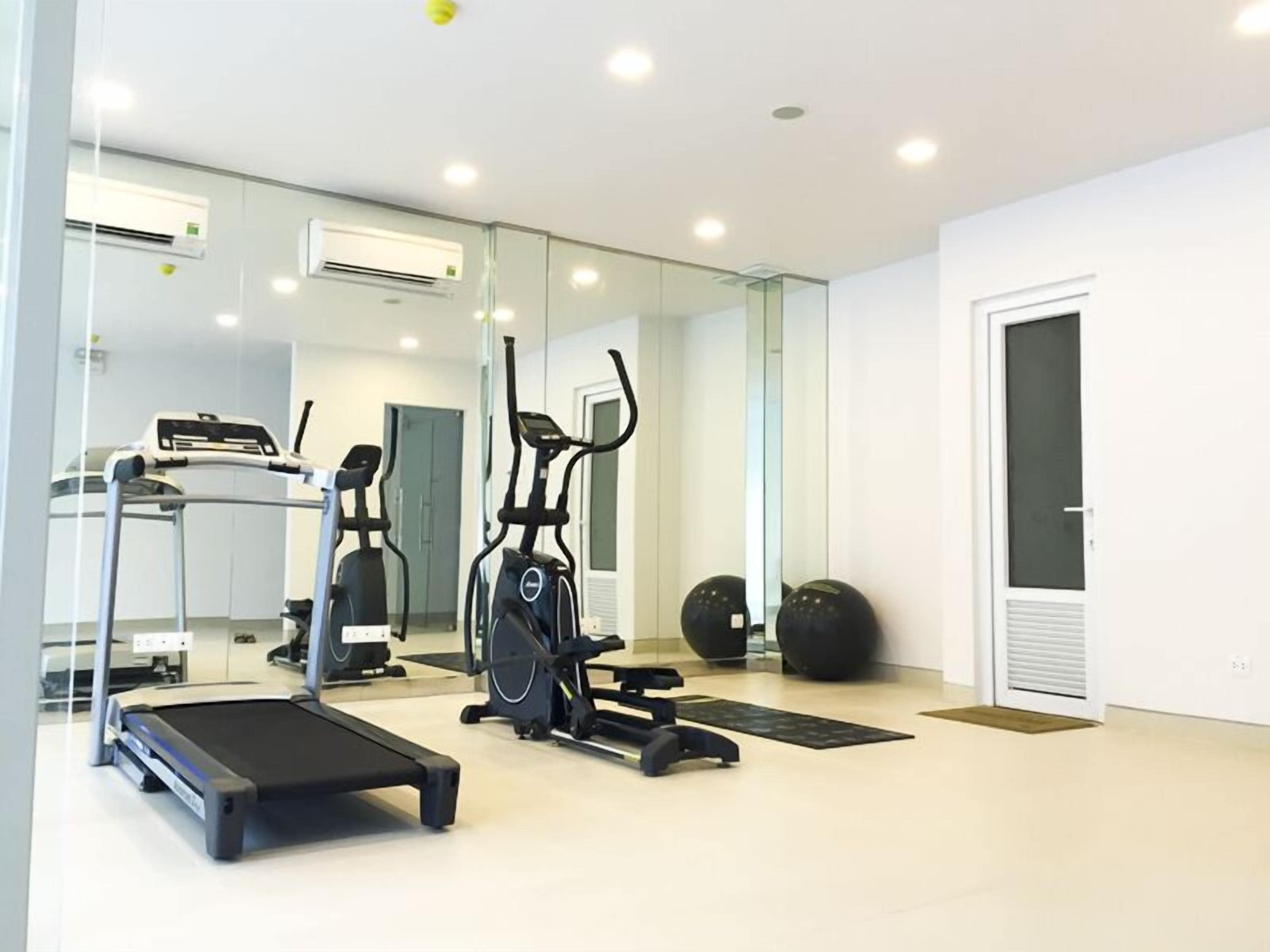 A modern gym with a treadmill, elliptical, and stationary bike.