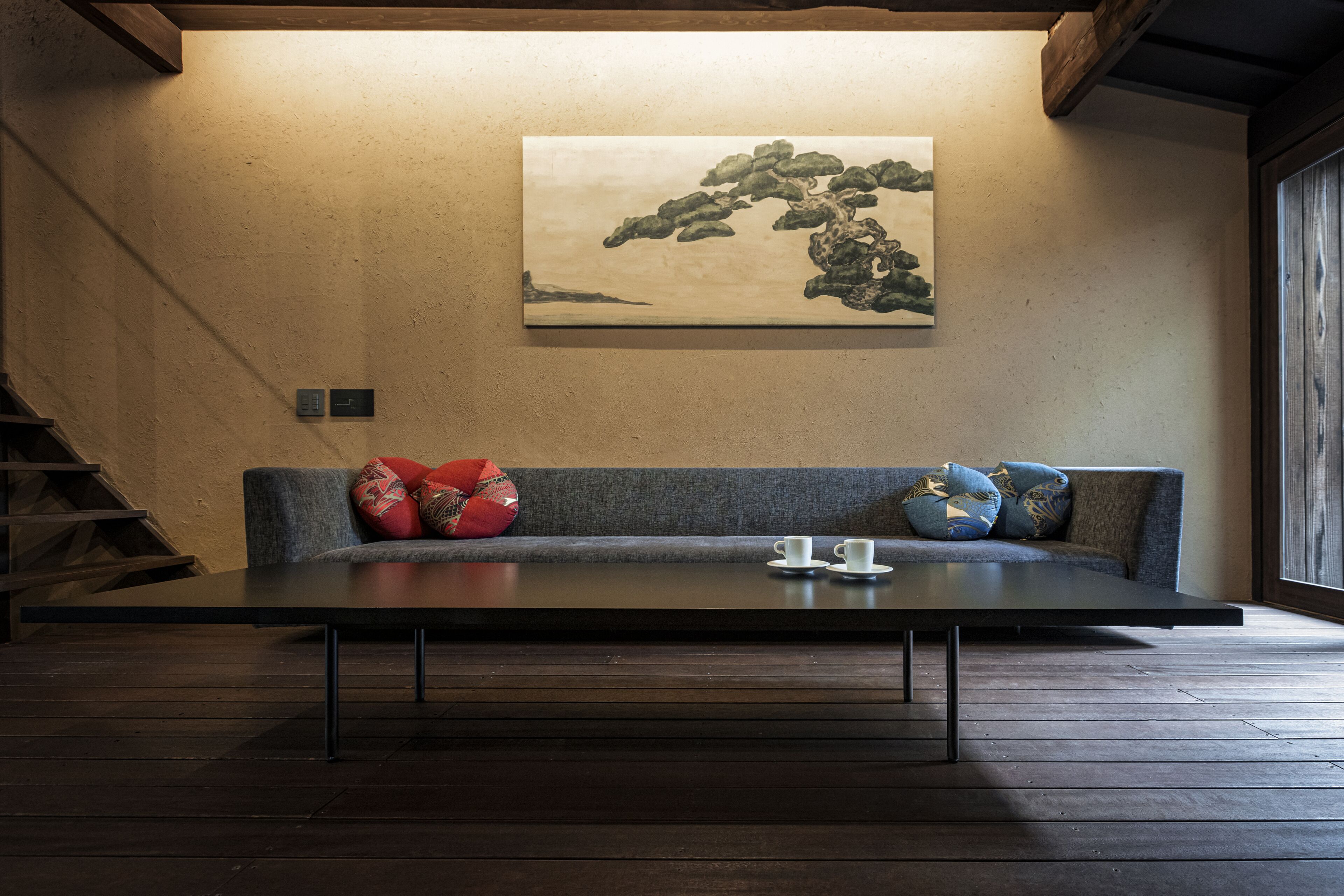 Un intérieur moderne avec un canapé, une table et un tableau au mur.