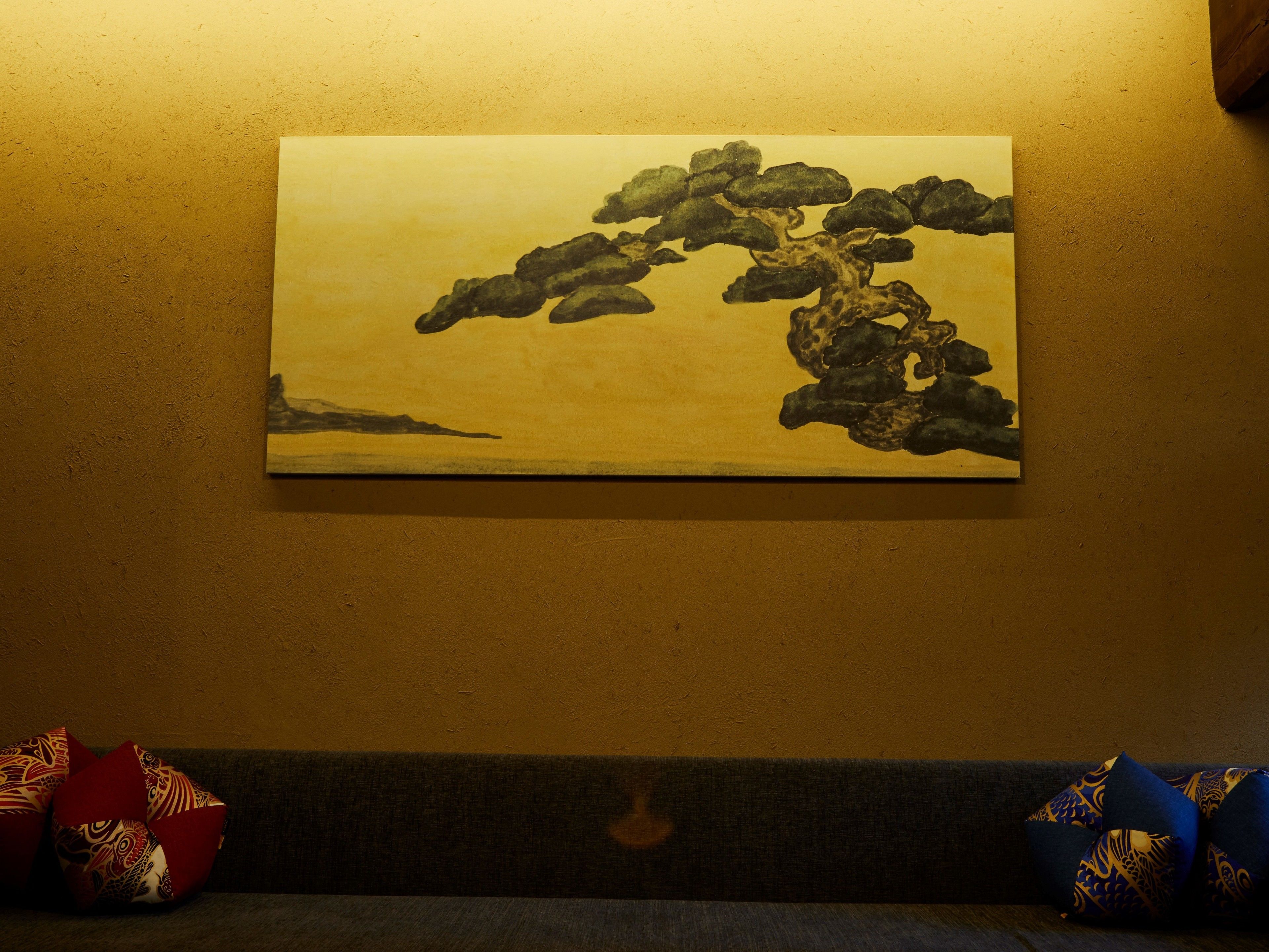 A painting of a tree on a textured wall.