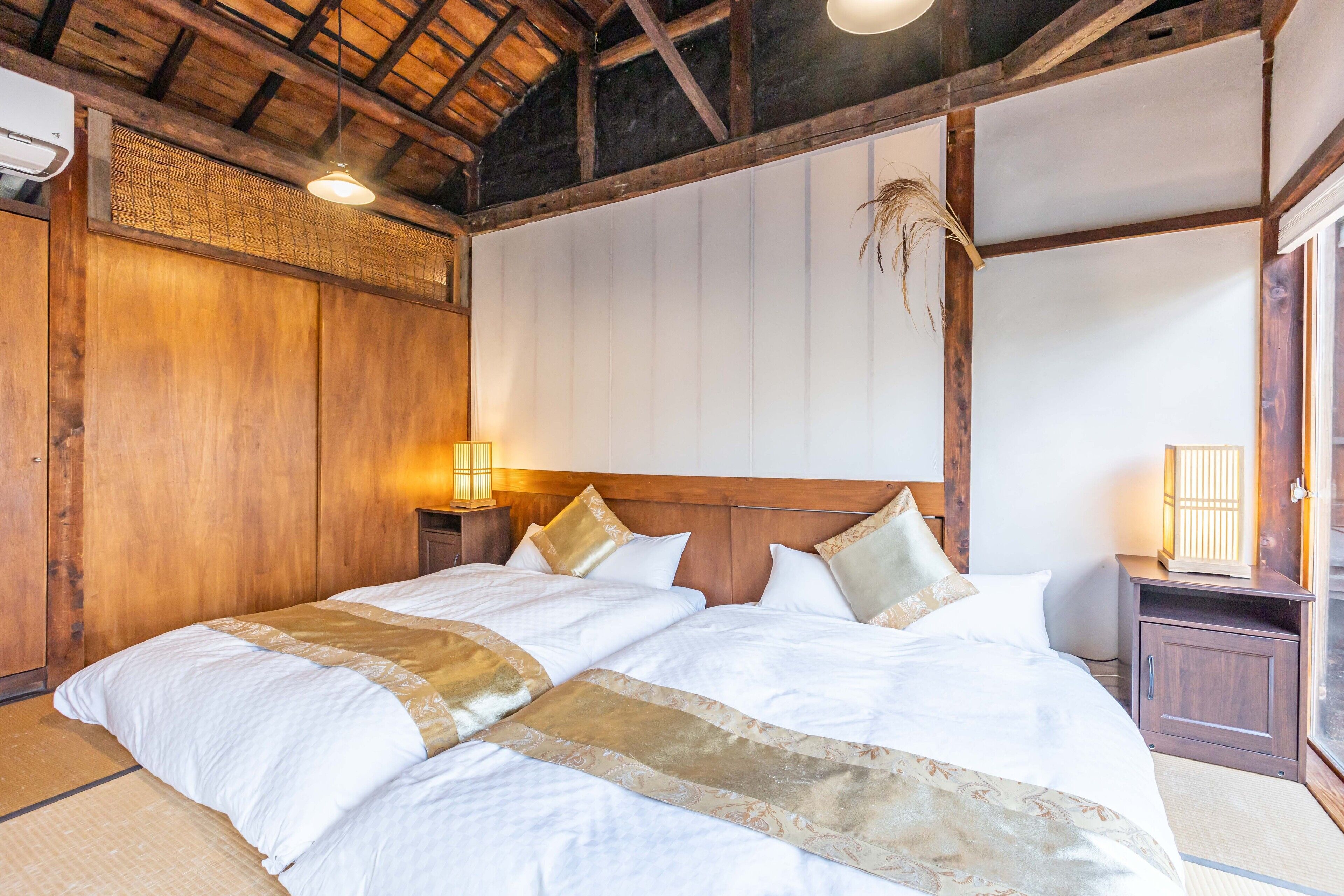A traditional Japanese-style bedroom with a wooden ceiling and tatami flooring.