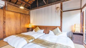 A traditional Japanese-style bedroom with a wooden ceiling and tatami flooring.