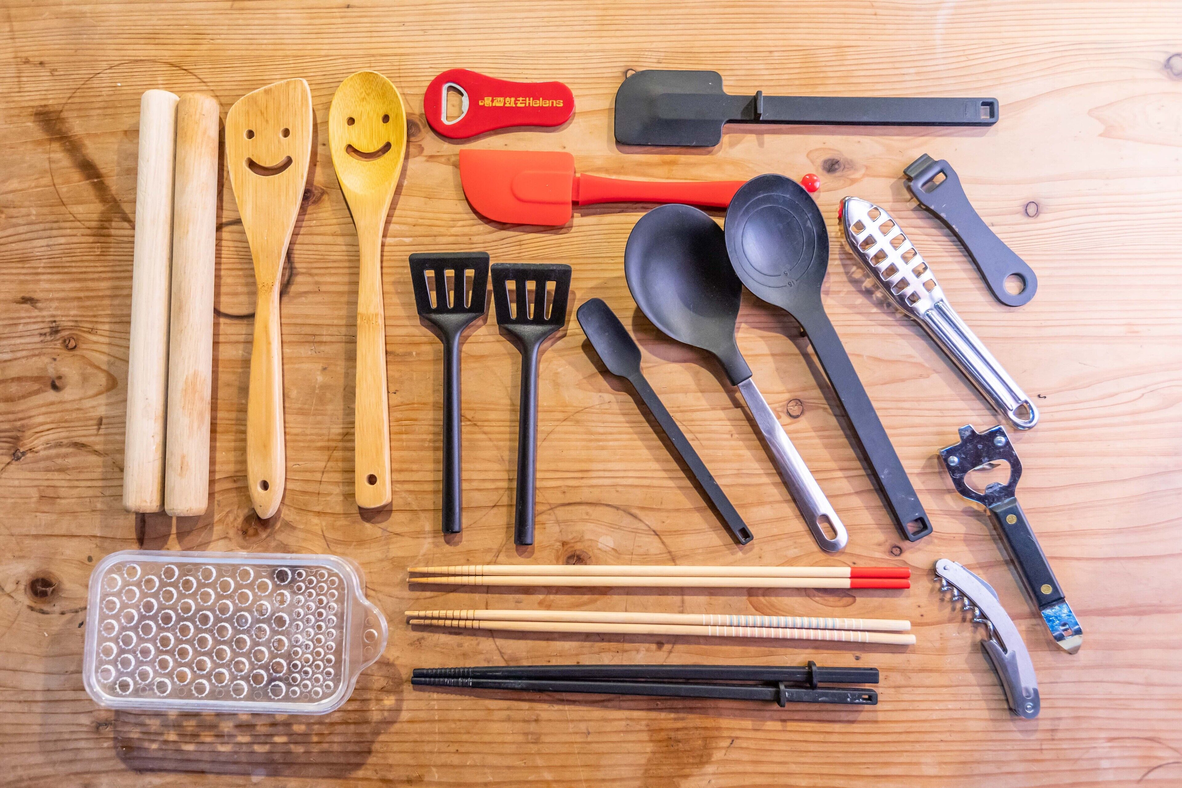 Une variété d’ustensiles et d’outils de cuisine disposés sur une surface en bois.