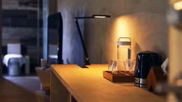 A wooden table with a coffee maker, a glass carafe, and a tray of glasses.
