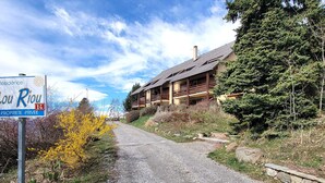 A gravel path leading to a lodge with a wooden exterior and multiple balconies.