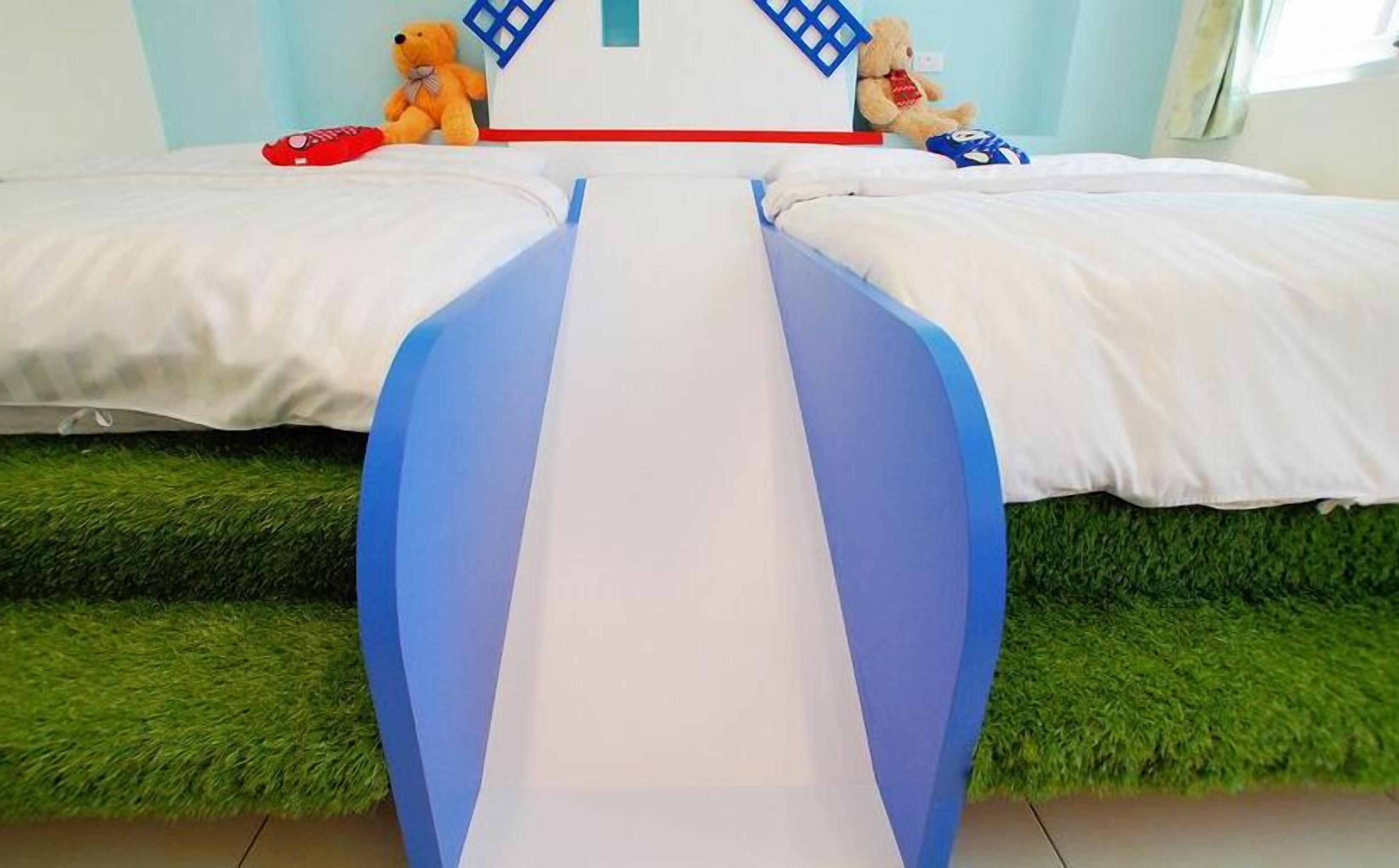 A bed with a blue and white slide in the middle.