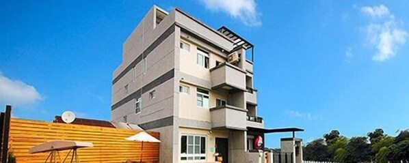 A multi-story residential building with a flat roof, a balcony on the upper floor, and a satellite dish on the roof. - Happy to Meet B&B (Taitung)