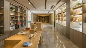 Eine moderne Bibliothek mit Holzbögen, einem zentralen Leseplatz und einem klaren, minimalistischen Design.